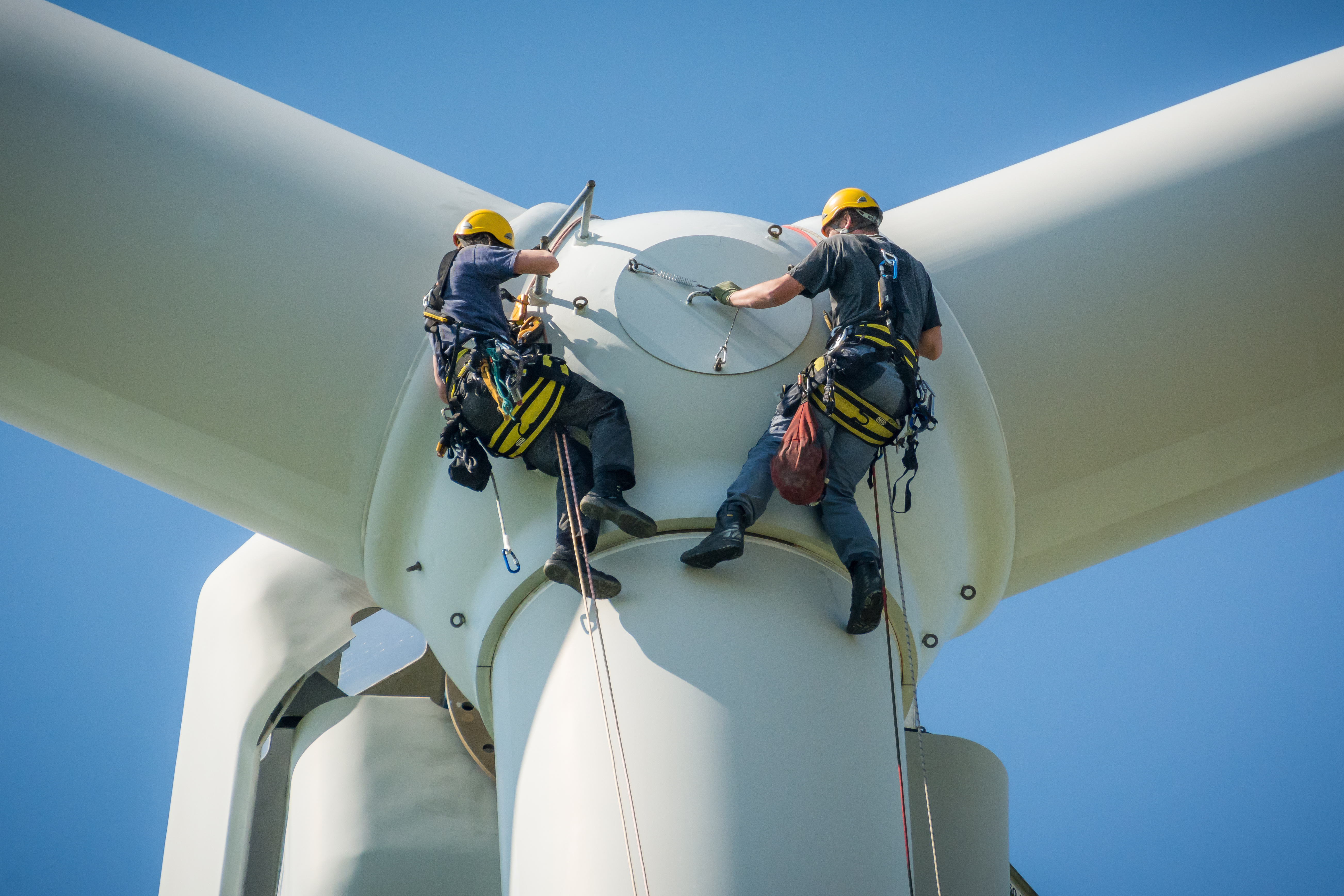 Wind turbine technicians inspecting a hub with rope access
